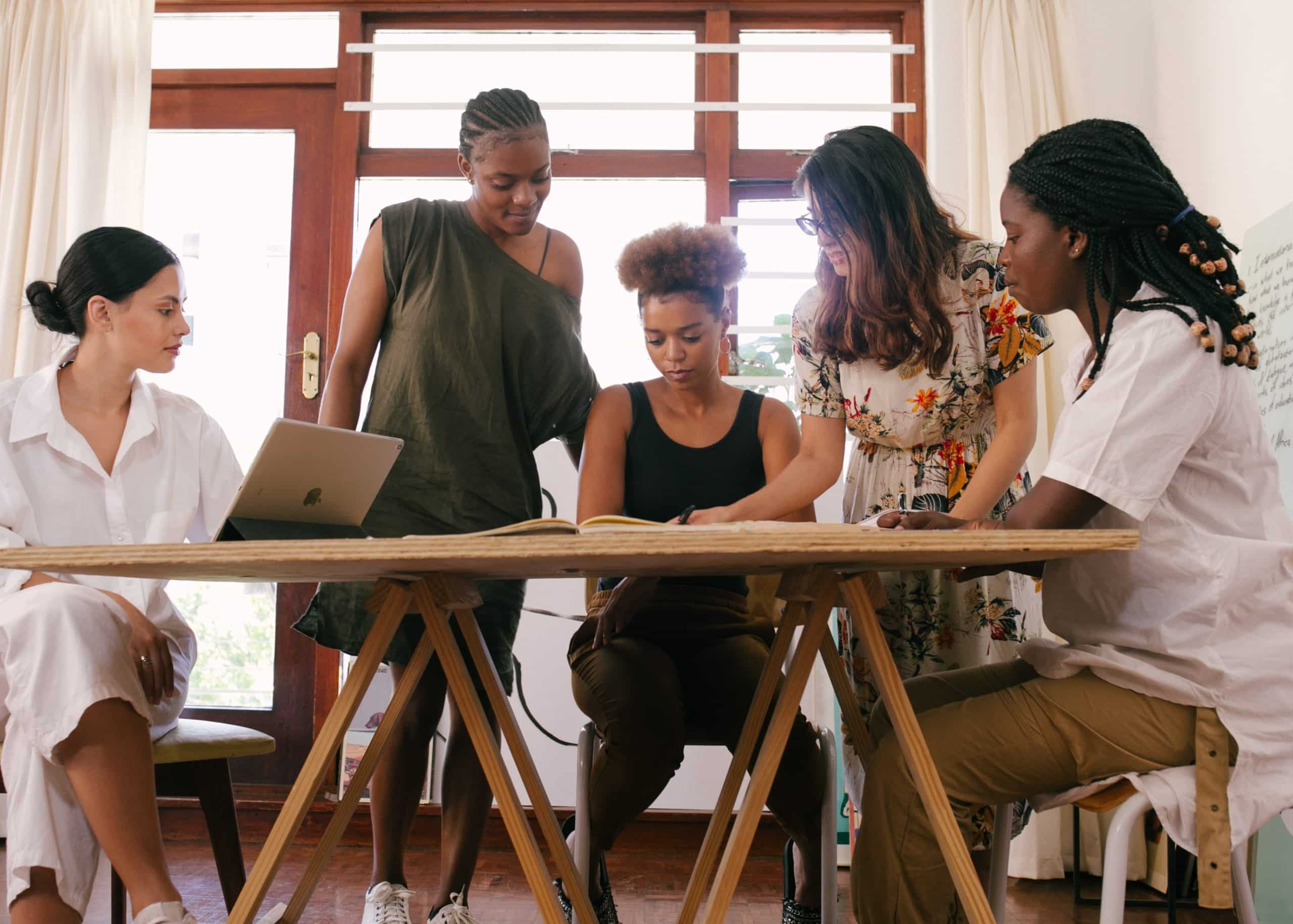 group of women working together at a wooden table